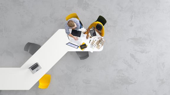 Overhead view of two architects working on a project in the office