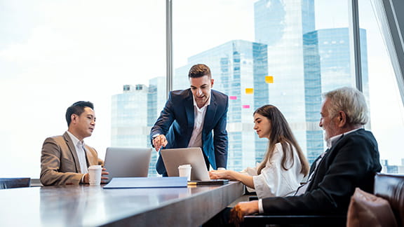 People gathered around a desk in a high rise office.