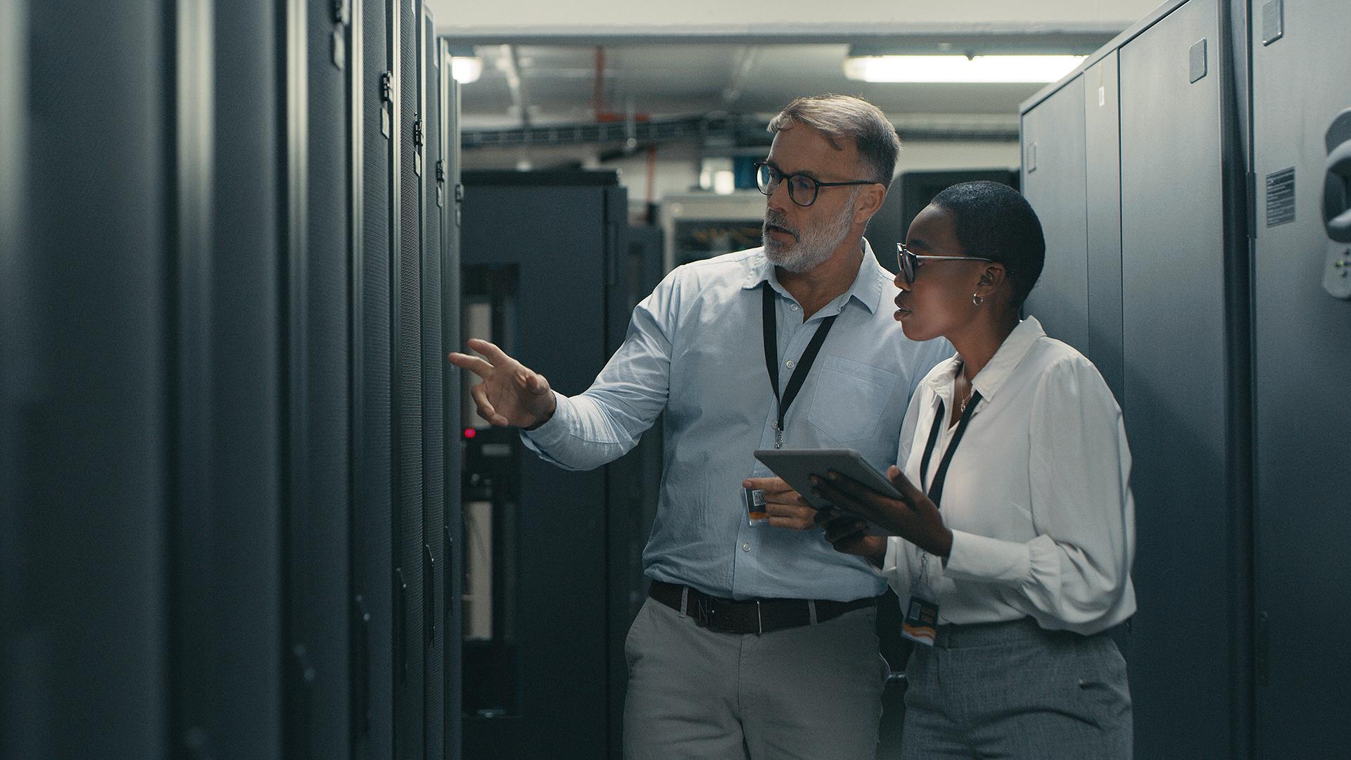 Shot of a man and woman using a digital tablet while working in a data center