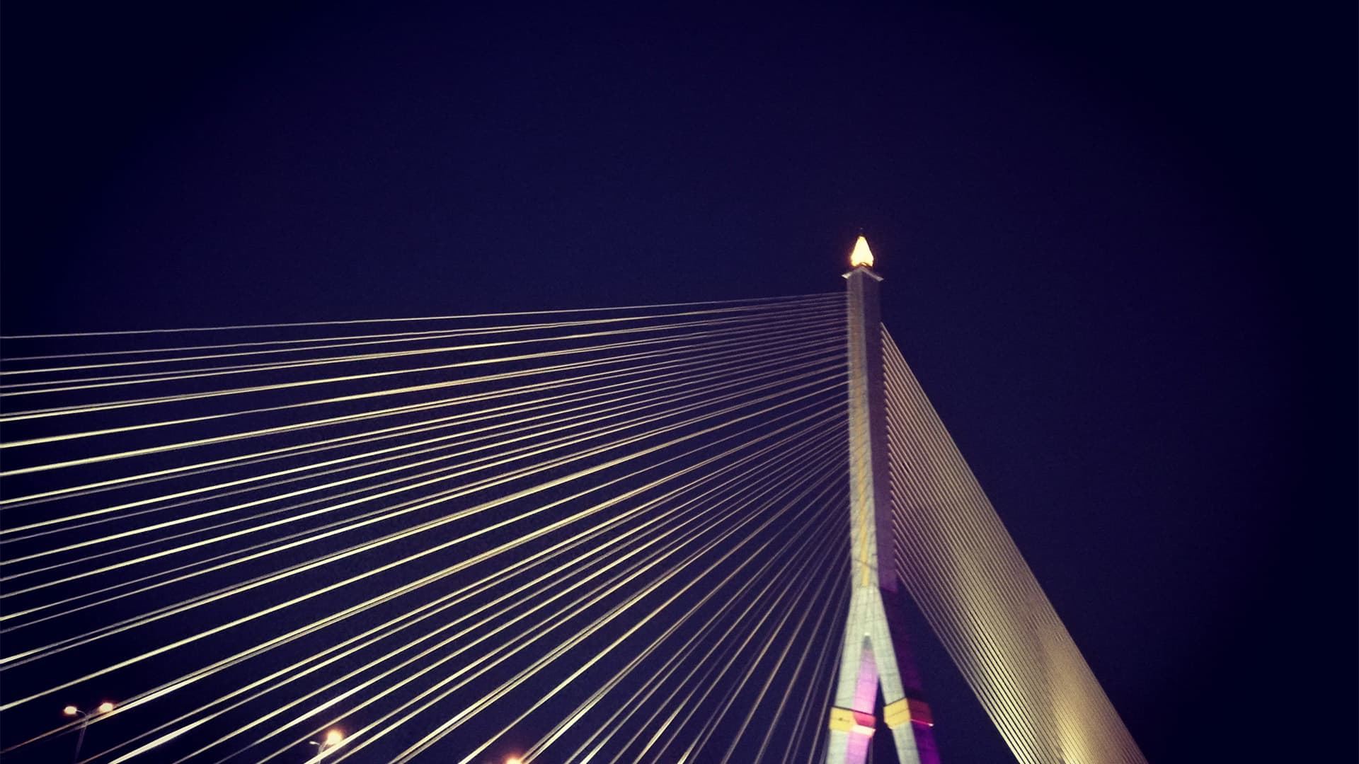 Cable-stayed bridge lit up at night.