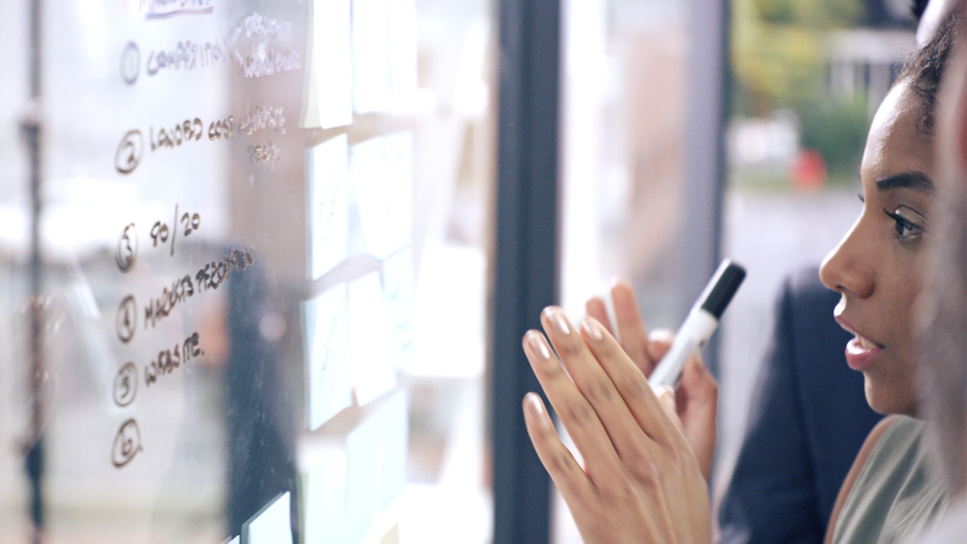 A young businesswoman having a brainstorming session with her team in a modern office.