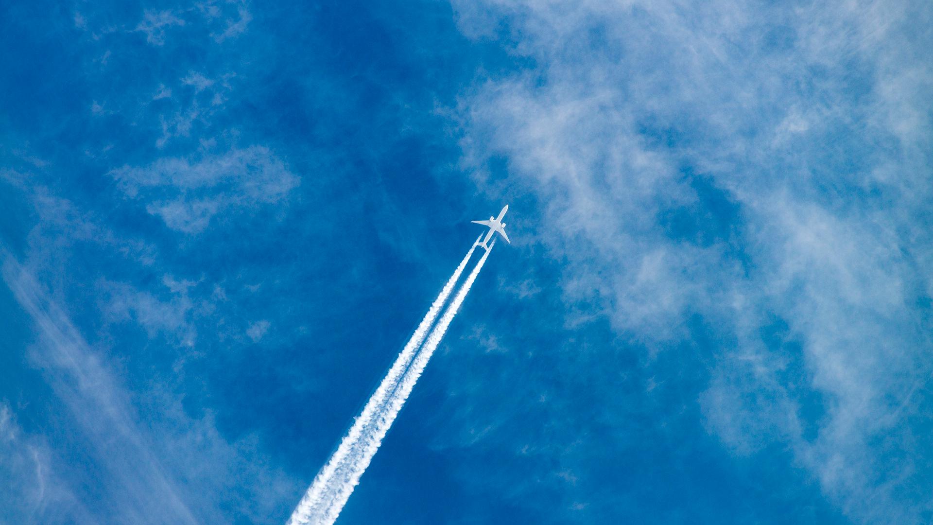 An aircraft in the sky seen from the ground.