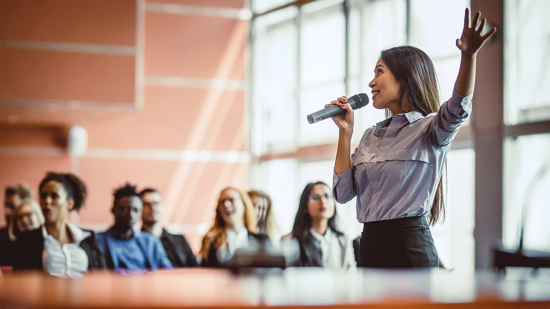 A woman at a conference giving a talk.