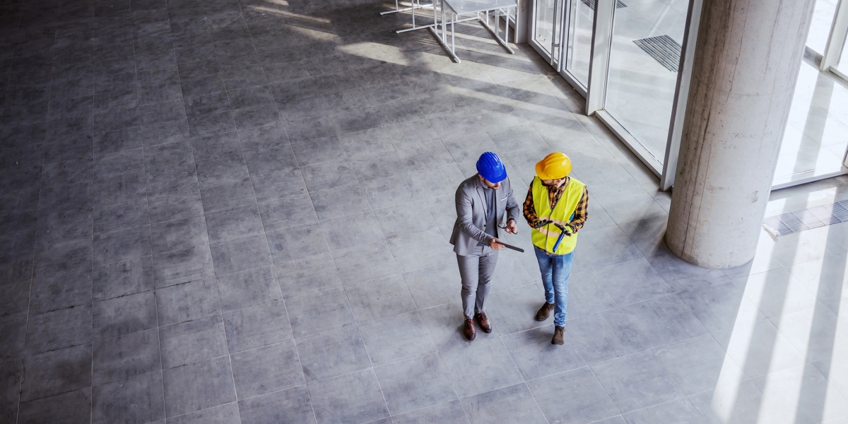 Construction worker talking to a man in a suit 