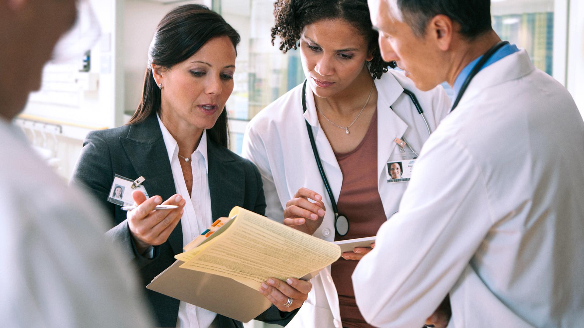 A group of physicians looking at a patients chart.