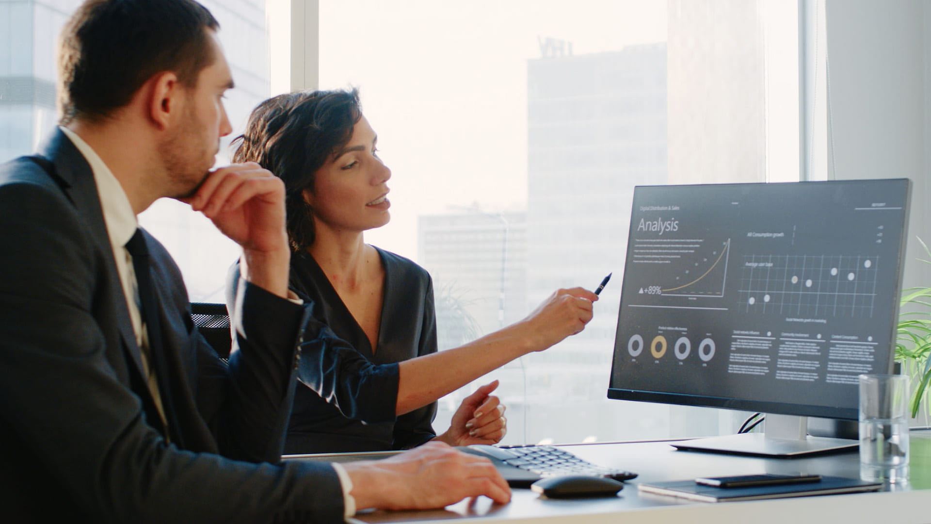 Female Top Manager and Male Businessman Sitting at the Desk Having Discussion and Working on a Desktop Computer