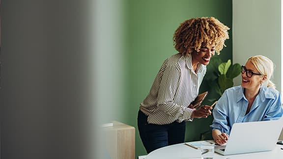 Two people looking over financial records at a computer.