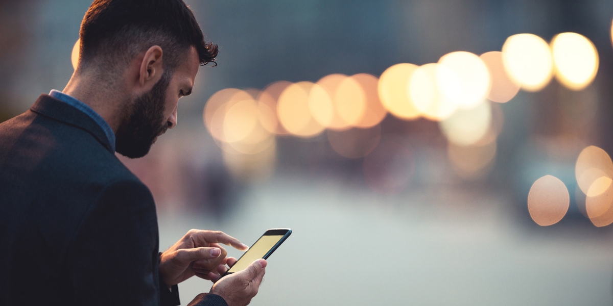 Business man on his phone on a busy city street.