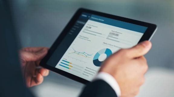 business man with tablet displaying charts and graphs