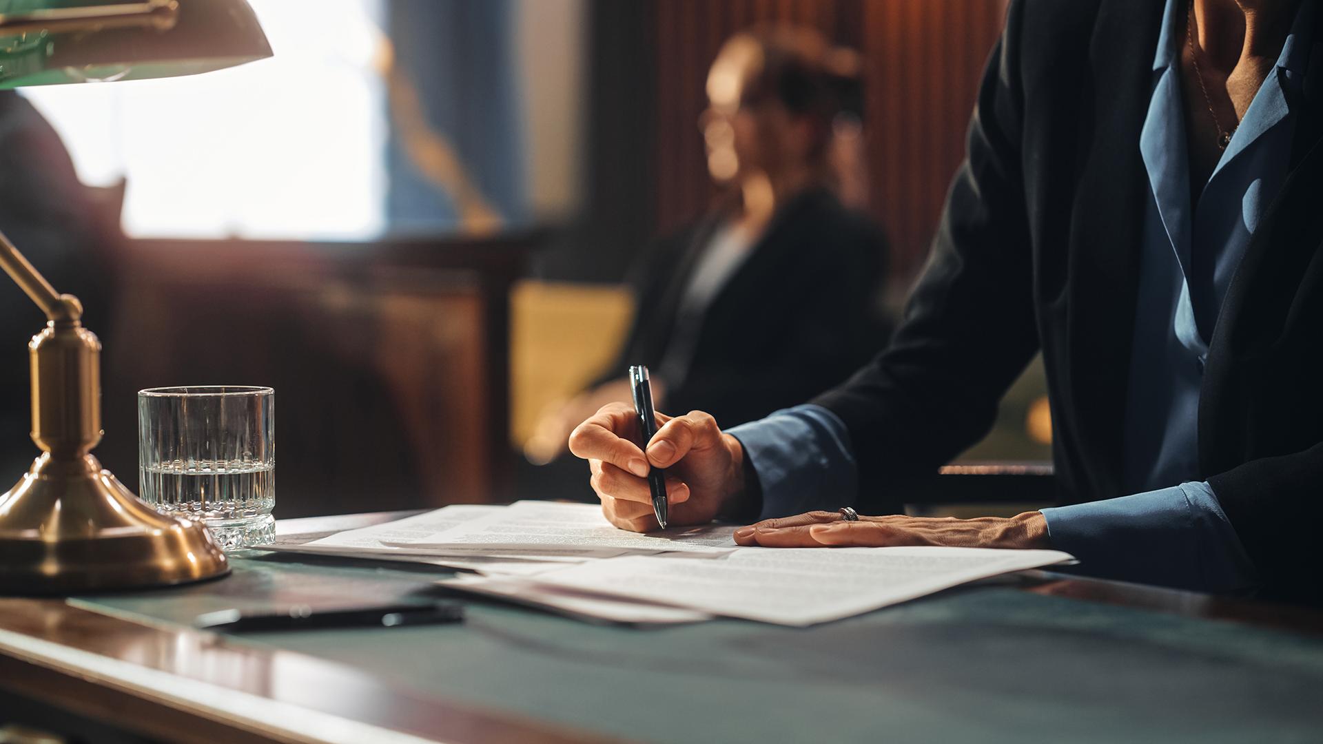 man in a suit with a signing a document with a pen in a bank