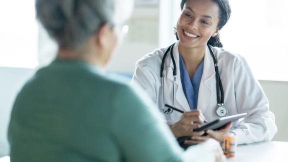 A doctor and a patient talking about patient care.