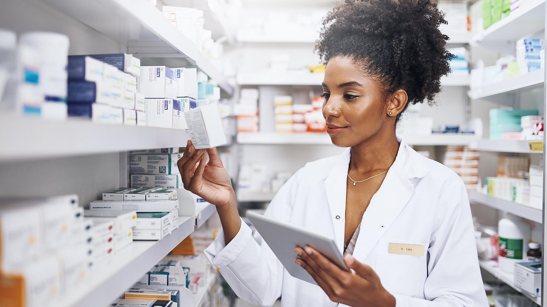 A female pharmacist selecting a medication to fulfill a prescription.