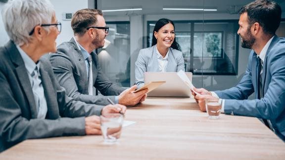 Business professionals gathered in a conference room.