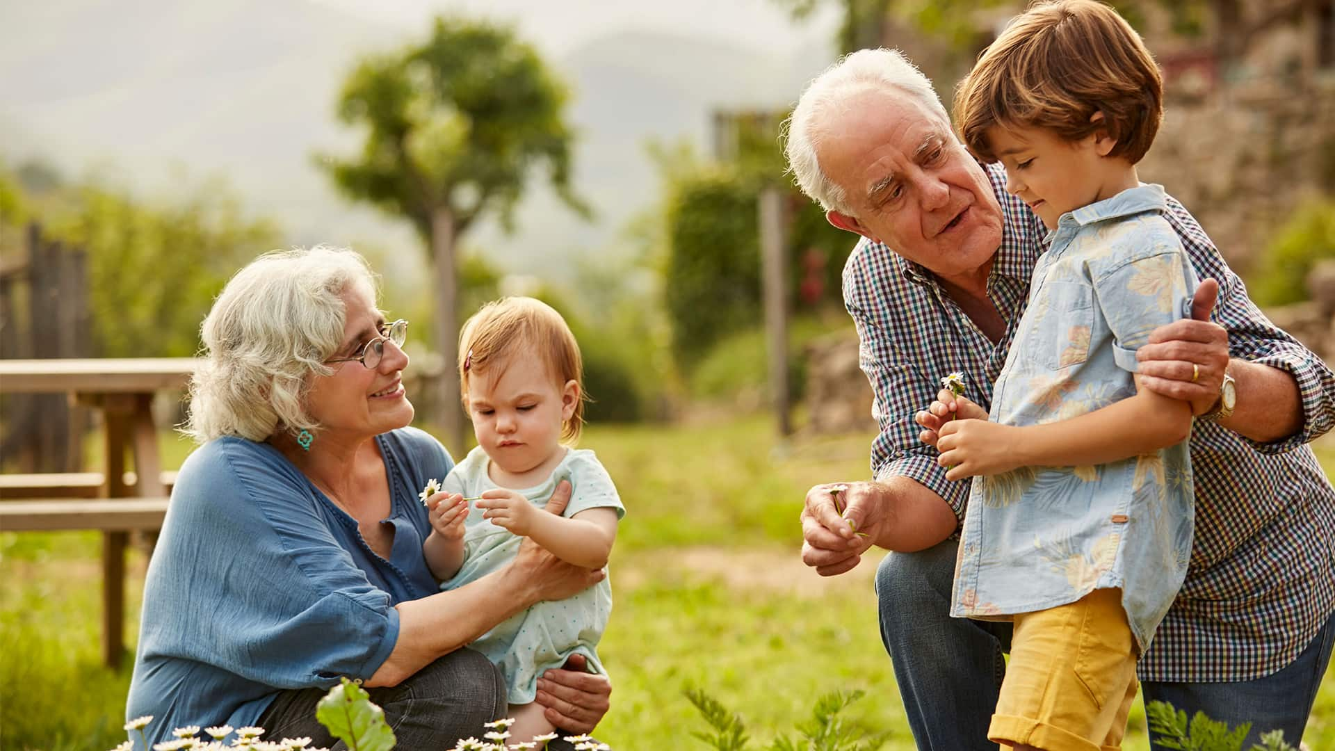 Grandparents spending quality time with their young grandchildren in a backyard.