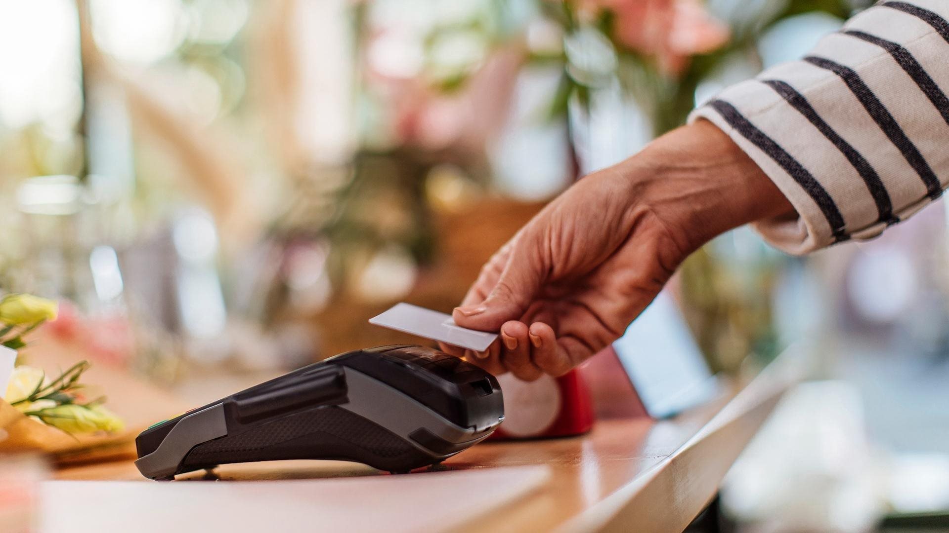 A woman paying for a transaction with tap to pay credit card.