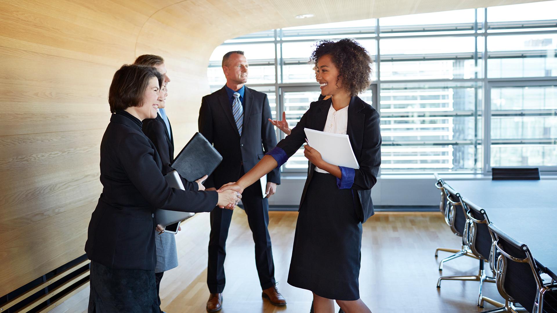 Large group of corporate business people shaking hands at meeting