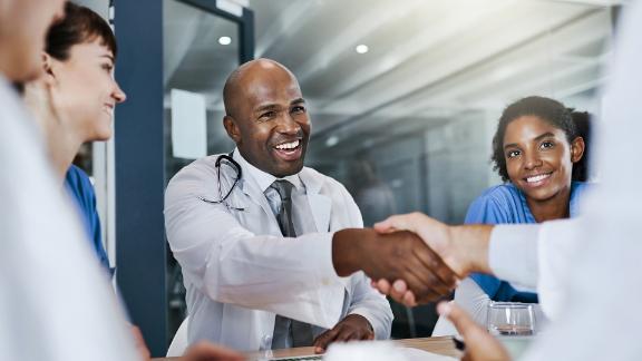 Doctors shaking hands and gathering in a medical facility 