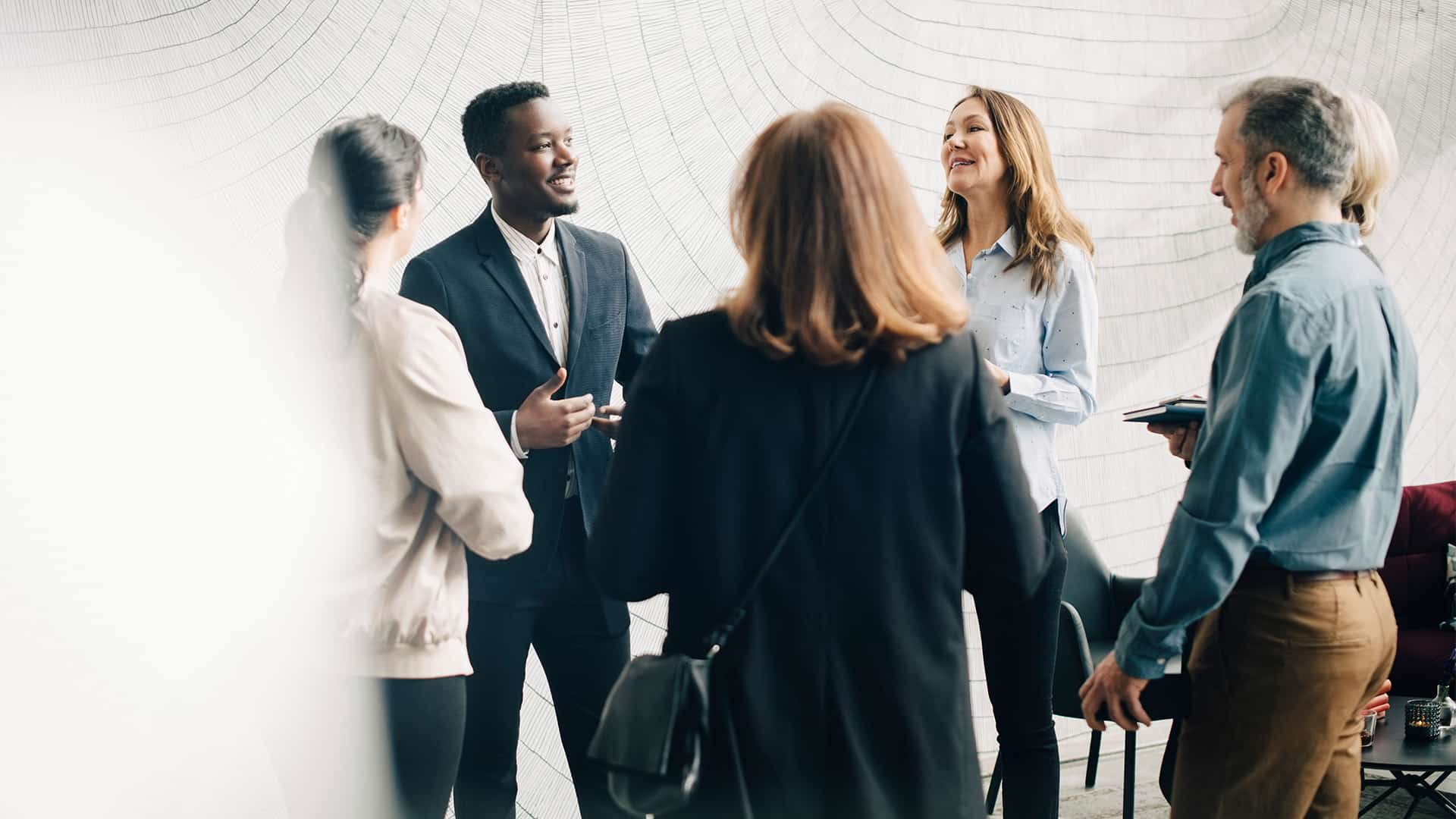 A group of colleagues gathered around and conversing.