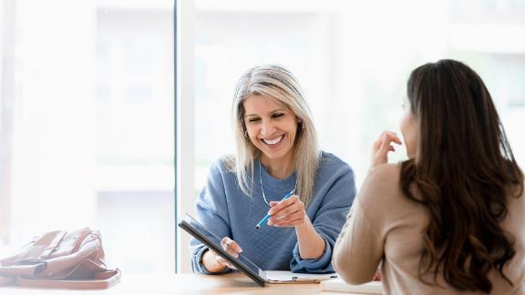 Female financial advisor reviews documents on digital tablet 