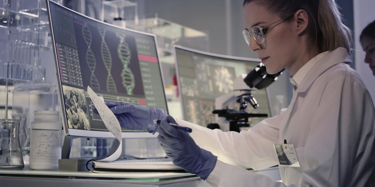 A woman scientist in a lab, looking over documents about DNA research.