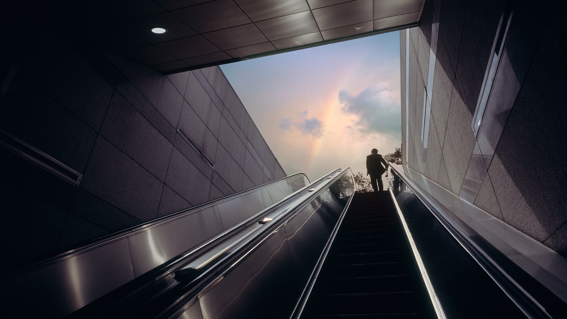 A person riding an escalator up to street level from a subway station.