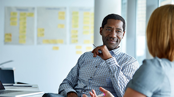 Two colleagues talking in an office.