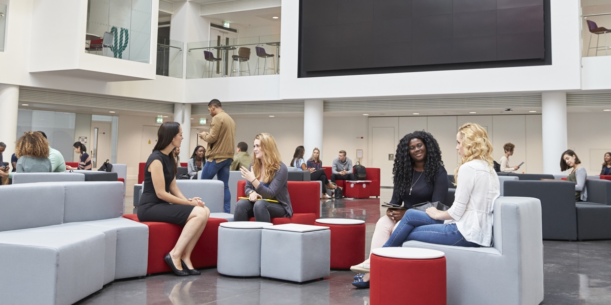 Young university students sitting in a student center and chatting.