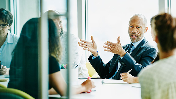 Mature businessman leading project meeting in office conference room